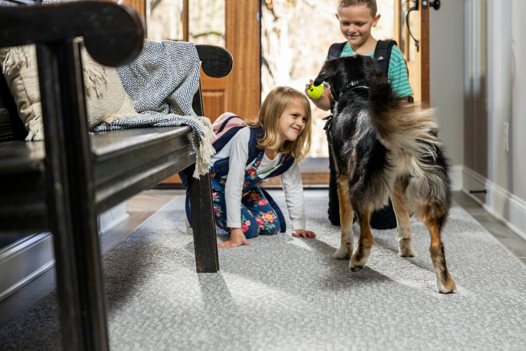 Kids plying with dog on carpet flooring | Leicester Flooring